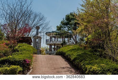 Jinan, South Korea; April 21, 2020: Concrete Monument And Three Story Pavilion At Top Of Hill In Pub