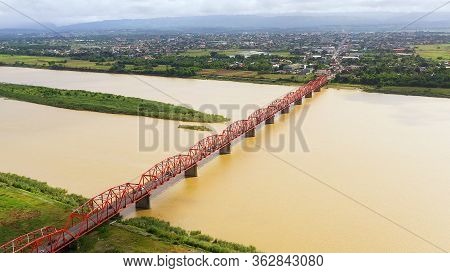 Bridge Over The Cagayan River, Philippines, Aerial View. Road Bridge Over A Wide River. Cars Ride On