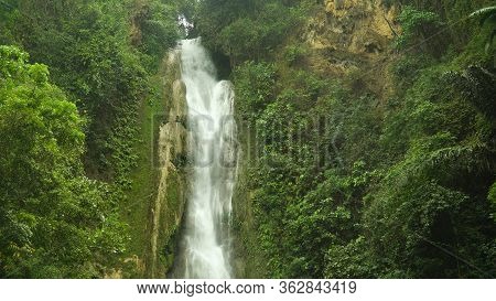 Jungle Waterfall In A Tropical Forest Surrounded By Green Vegetation. Mantayupan Falls In Mountain J