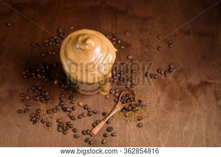 Cold Dalgona Coffee In Clear Glasses On A Dark Wooden Background. Froth Of Sugar And Instant Coffee