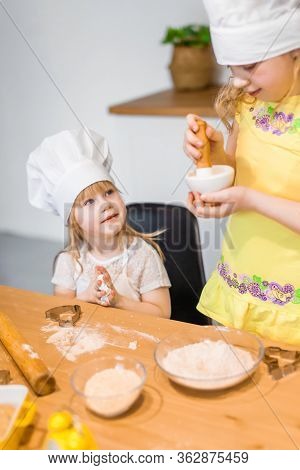Family Scene At Home - Two Cute Lettle Sisters Happily Baking Cookies And Buns