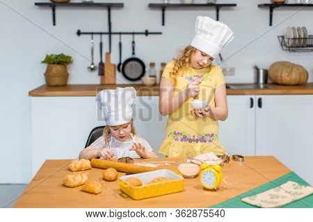 Family Scene At Home - Two Cute Lettle Sisters Happily Baking Cookies And Buns