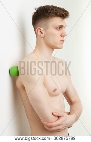 Handsome Man Shows Exercises Using The Ball With Spikes