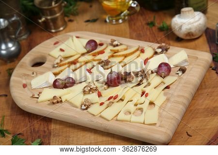 Wooden Plateau With Fresh Grapes Figs And Types Of Cheese Closeup As Homefood Background