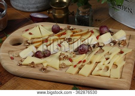 Wooden Plateau With Fresh Grapes Figs And Types Of Cheese Closeup As Homefood Background