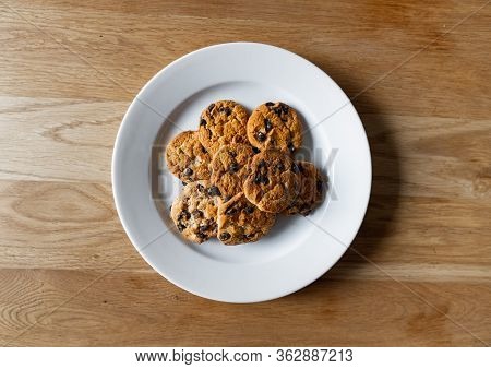 Top View Of Choc Chip Cookies In A White Plate On A Wooden Table. Homemade Chocolate Chip Cookies. B