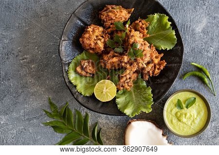 Indian Cuisine. Pakora Traditional Indian Deep-fried Snack. Pakoras On Black Plate With Coconut Chut