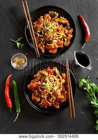 Spicy Garlic Fried Chicken (kkanpunggi). Asian Chicken In Sweet And Sour Sauce On Plate Over Black S