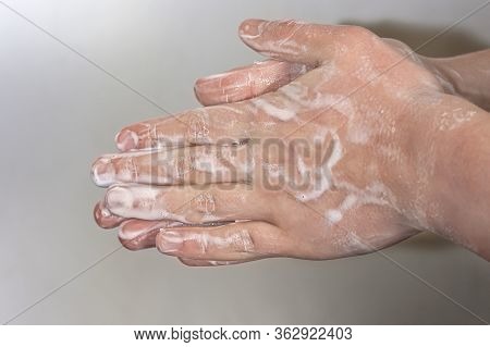 Hands Of A Young Guy In Soap Foam On A Grey Background. Hand Washing. Minimal Hygiene, Virus Protect