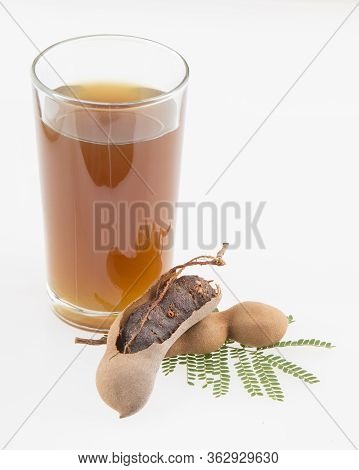 Tamarind Juice In A Glass Surrounded By Fresh Ripe Tamarinds - Tamarindus Indica