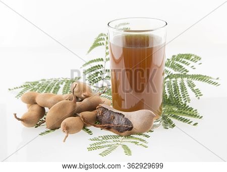 Tamarind Juice In A Glass Surrounded By Fresh Ripe Tamarinds - Tamarindus Indica