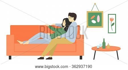 Happy Woman And Man Spend Time Together At Home. The Husband Sits On The Couch And Hugs His Wife.