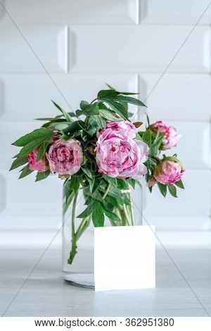 Bouquet Of Pink Peonies In Glass Vase Against White Background And Wooden Table. Mothers Day Card. B