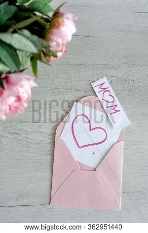 Bouquet Of Pink Peonies In Glass Vase Against White Background And Wooden Table. Mothers Day Card. B