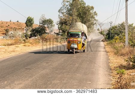 Puttaparthi, Andhra Pradesh, India - January 12, 2013: Indian People Travel In Rickshaw Taxi Along T