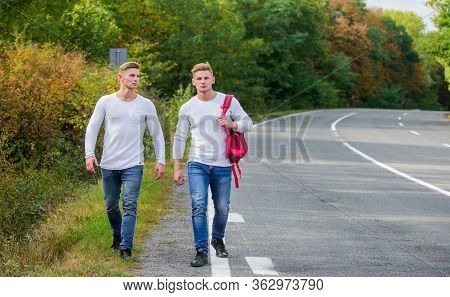 Pick Spot Where Car Can Easily Pull Aside. Men Backpack Walking Road. Twins Walk Along Road. Adventu