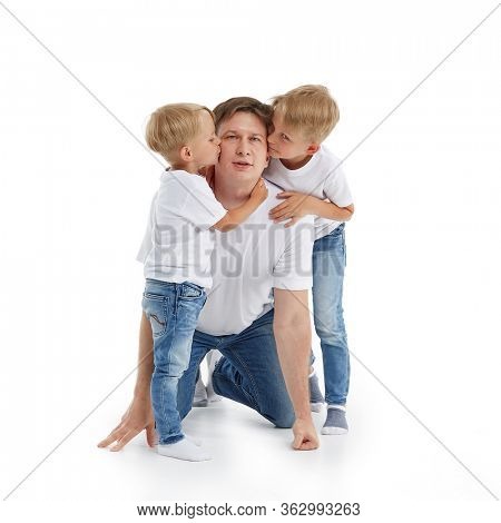 Friendly family. Little children are embrasing and kissing father isolated on a white background.  Happy parent. Father with two sons. Parenting