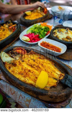 Fish Dish In Tropic Restaurants On The River. Places On The River With Tourists In Forest, Turkey
