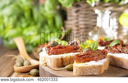 Bruschetta With Sun-dried Tomatoes, Cheese, Basil And Capers. Traditional Appetizer For Aperitivo In