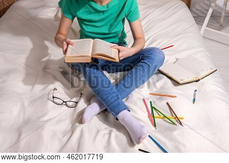 A Girl In A Green T - Shirt And Blue Jeans Is Sitting On The Bed And Writing In A Notebook , Colored