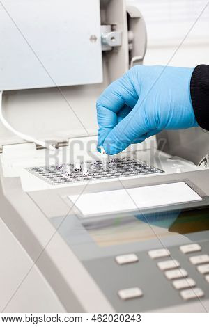 Closeup Of A Scientist Hand While Working At The Laboratory With A Thermal Cycler. Polymerase Chain 