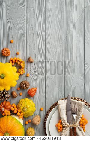 Thanksgiving Day Concept. Top View Vertical Photo Of Plate Knife Fork Napkin Rowan Pumpkins Pattypan