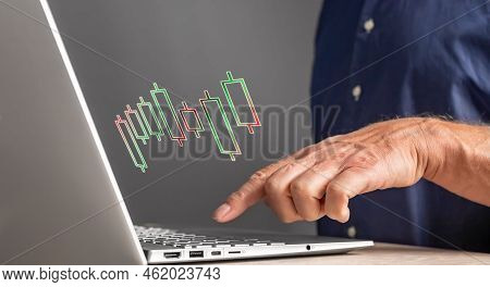 Man Working With Candlestick Chart On Laptop. Stock Market Analysis. Finance, Investment, Trade Conc