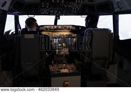 Diverse Team Of Aircrew Members Using Control Command To Fly Plane In Aircraft Cockpit, Pushing Powe