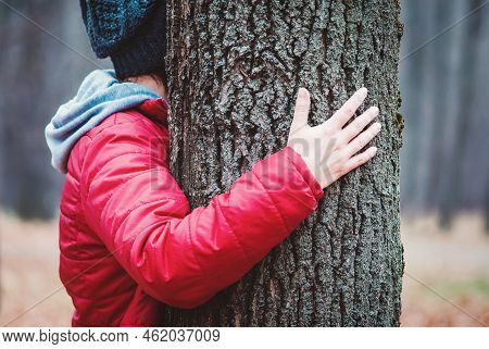 Hugging Tree Trunk In Autumn Park, Woman Embraces Old Tree Outdoors, Love And Unity With Nature