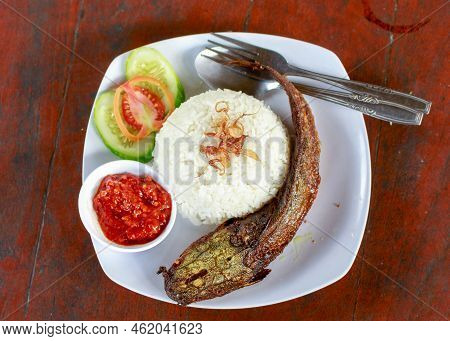 Indonesian Special Food. Close Up Pecel Catfish Served On A White Plate Placed On A Wooden Table