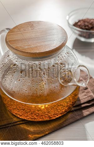 Glass Teapot With Aromatic Buckwheat Tea And Granules On Wooden Table, Closeup