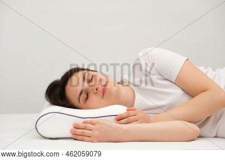 A Woman Sleeps On An Orthopedic Pillow Made Of Memory Foam, Lying On A Bed. The Correct Pillow For A