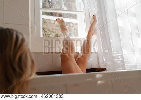 A Beautiful Mature Woman Massages Her Legs In A Bath With Candles In A Cozy And Comfortable Atmosphe