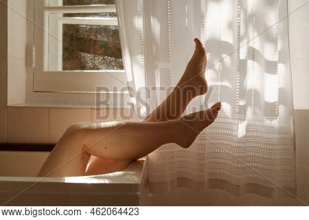 A Beautiful Mature Woman Massages Her Legs In A Bath With Candles In A Cozy And Comfortable Atmosphe