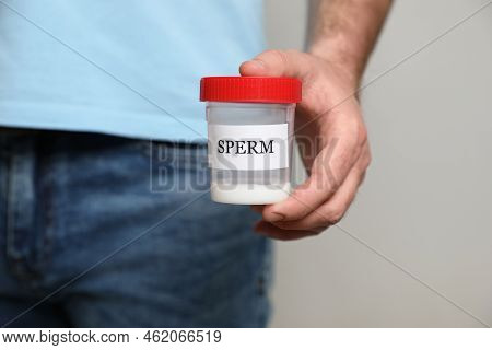 Donor Holding Container With Sperm On Beige Background, Closeup