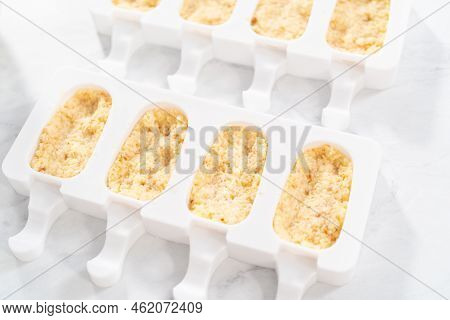 Filling Silicone Molds With Cake Crumbs To Prepare Mermaid Cakesicles.