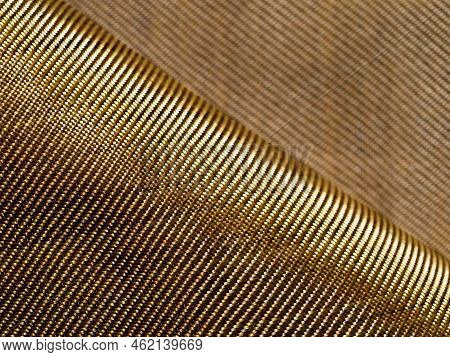 Selective Focus. The Bend Of The Golden Fabric Bulletproof Material Aramid. Aramid Kevlar Background