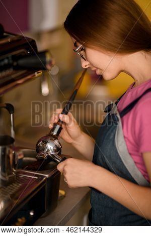 Close-up View On Woman Barista Tamping Coffee In Portafilter With Tamper.