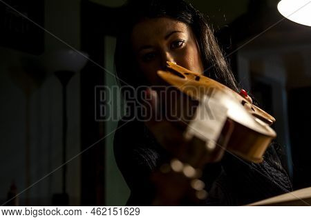 Young Woman Apprentice Violinmaker Checking Her Violin