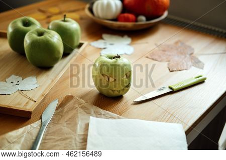 Halloween Fruit Ideas. Halloween Green Apple With Creepy Carved Face On Wooden Table At Home. Health