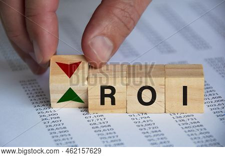 Return On Investment Text On Wooden Blocks With Hand Turn Wooden Block With Up And Down Symbol. Inve