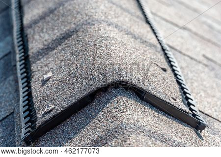 Ridge Cap Vent Installed On A Shingle Roof For Passive Attic Ventilation On A Residential House.