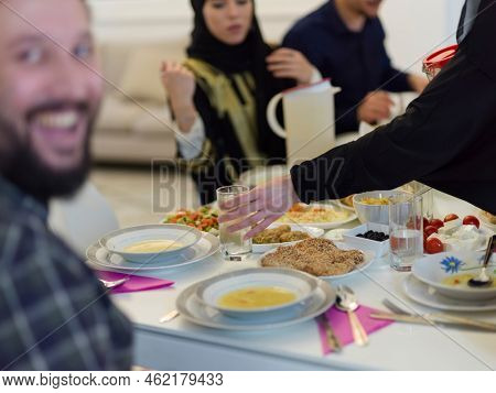 Muslim family making iftar dua to break fasting during Ramadan.