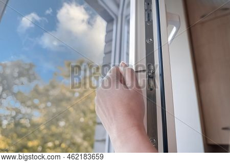 Adjusting The White Plastic Window. A Worker Uses A Hexagon To Repair A Window.