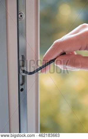 Adjusting The White Plastic Window. A Worker Uses A Hexagon To Repair A Window.