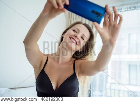 Young Sexy Woman Posing In Front Of Smartphone In His Hand And Working As Webcam Model