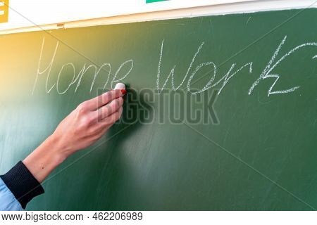 Homework Text On Green School Board And Girl Hand With Chalk.