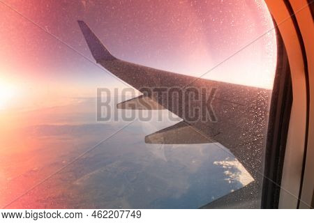 Plane Wing On Sunrise. Plane Comes In For A Landing In The Night Desert, The View From The Window On