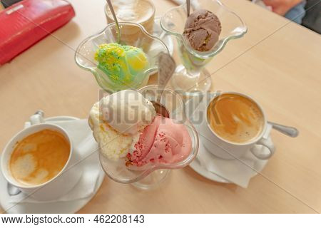Colored Ice Cream Balls With A Spoon And Cup Of Coffee Is Standing On Table In A Cafe. Delicious Ice
