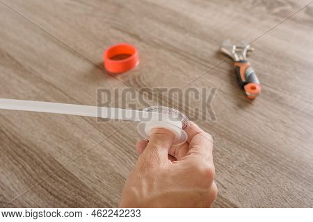 Man Winding Fum Tape For Fixing Pipe Leakage
